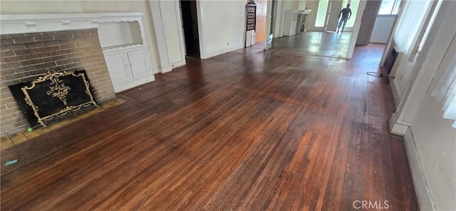 unfurnished living room with dark wood-style flooring and a fireplace