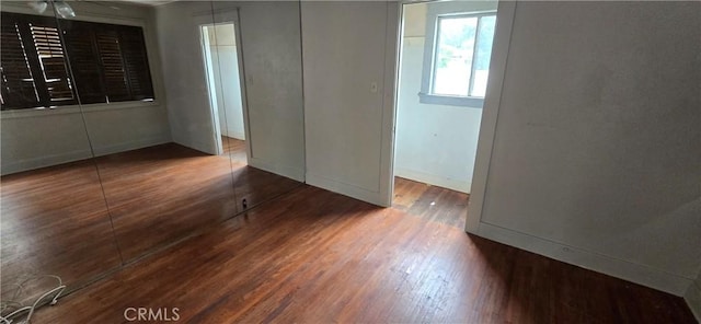 empty room with baseboards and wood finished floors