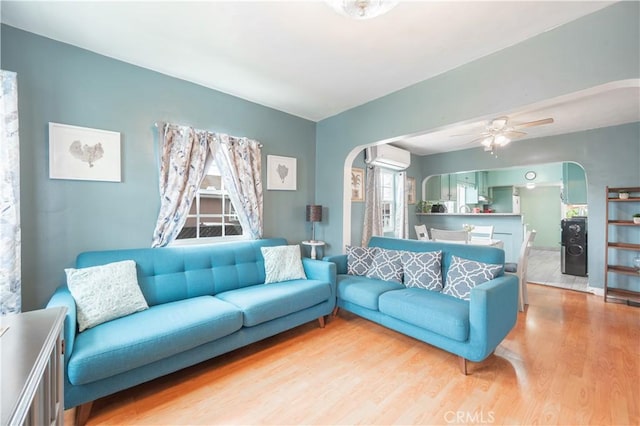 4253 Eugene St, Los Angeles, CA 90063 - living area with arched walkways, light wood-style floors, a wall unit AC, and ceiling fan