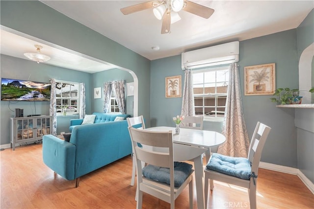 4253 Eugene St, Los Angeles, CA 90063 - dining area featuring wood finished floors, a ceiling fan, baseboards, arched walkways, and an AC wall unit
