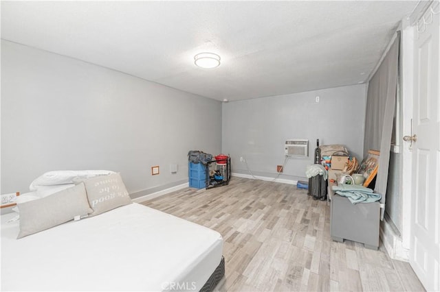 4253 Eugene St, Los Angeles, CA 90063 - bedroom featuring a textured ceiling, a wall mounted AC, baseboards, and light wood-type flooring