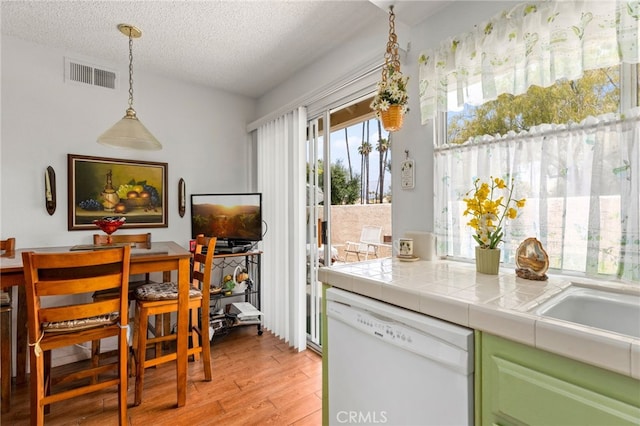 672 La Quinta Dr, Banning, CA 92220 - kitchen with decorative light fixtures, a textured ceiling, visible vents, dishwasher, and light wood finished floors