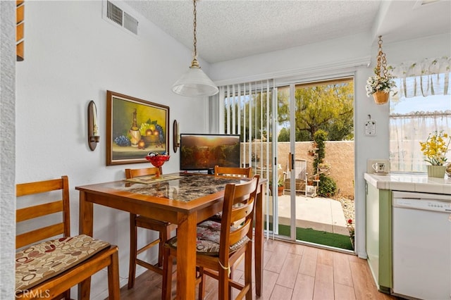 672 La Quinta Dr, Banning, CA 92220 - dining area featuring light wood-style flooring, a textured ceiling, and visible vents