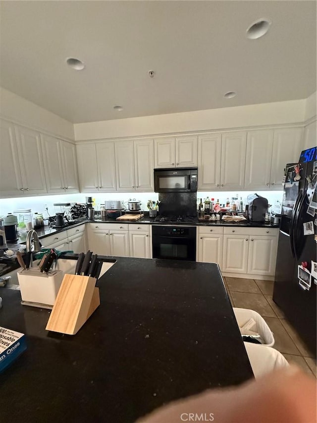 3591 Sacramento Dr Unit 86, San Luis Obispo, CA 93401 - kitchen featuring white cabinetry, black appliances, dark countertops, and light tile patterned flooring