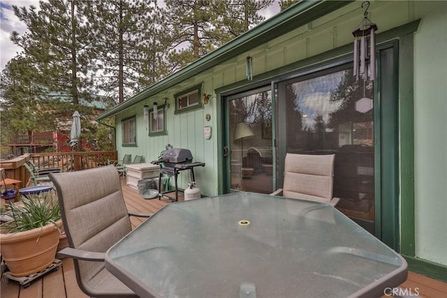 wooden deck with area for grilling and outdoor dining area