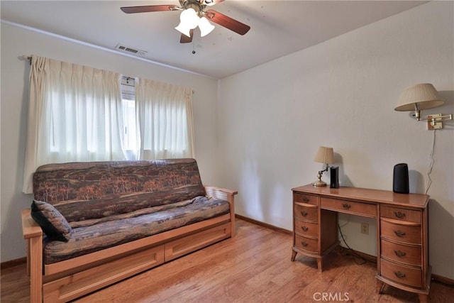 home office with light wood-style floors, visible vents, baseboards, and ceiling fan