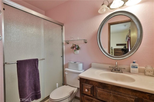 full bathroom with vanity, toilet, and a stall shower