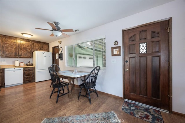 dining space with visible vents, wood finished floors, baseboards, and ceiling fan