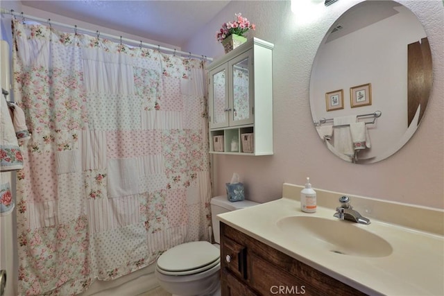 full bath with curtained shower, vanity, and toilet