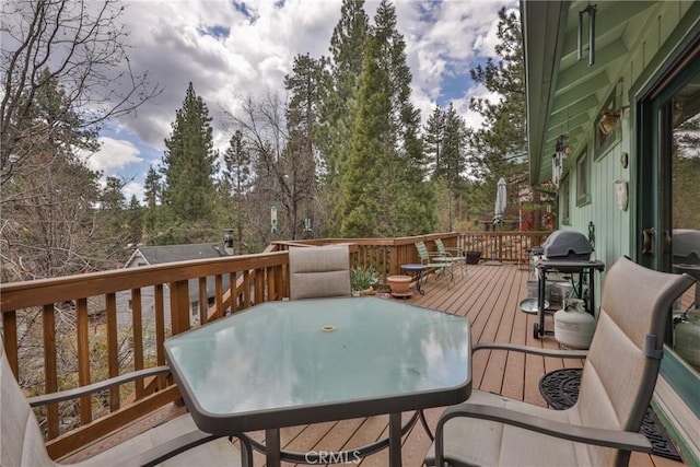 wooden deck with area for grilling and outdoor dining space