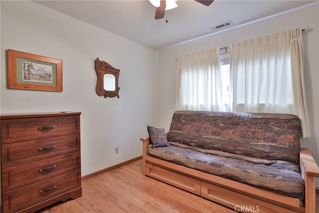 sitting room featuring baseboards, a ceiling fan, visible vents, and light wood-style floors