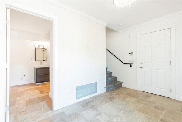 entrance foyer featuring stairs, ornamental molding, stone finish flooring, and visible vents