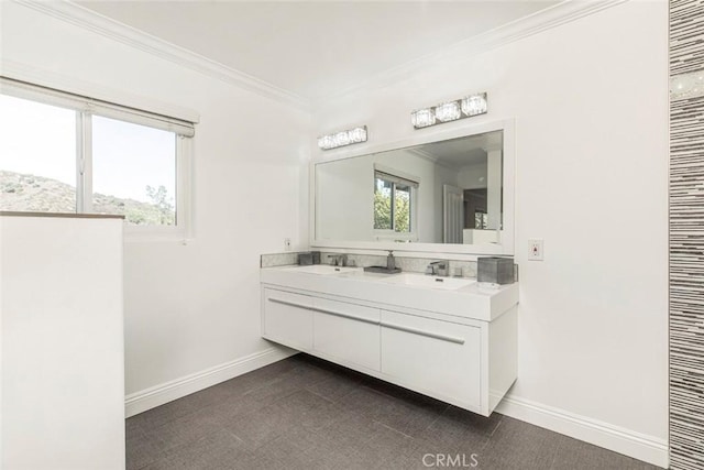 bathroom with baseboards, ornamental molding, double vanity, and a sink