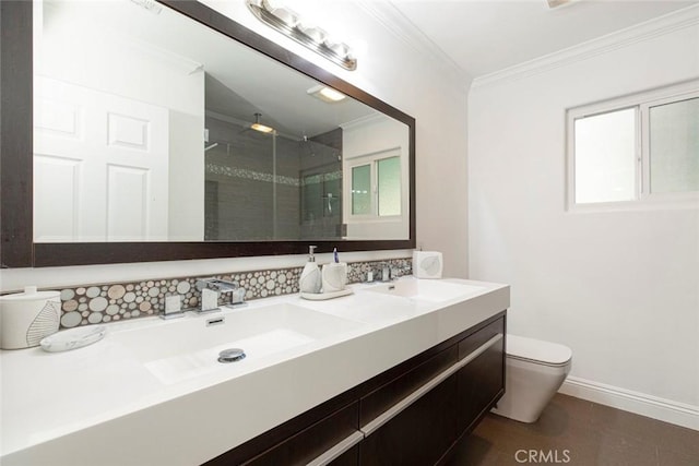 bathroom featuring a sink, ornamental molding, a stall shower, and toilet