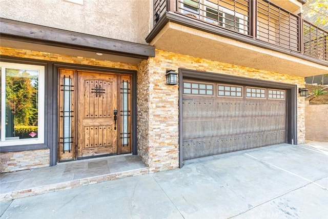 view of exterior entry featuring a garage and stucco siding