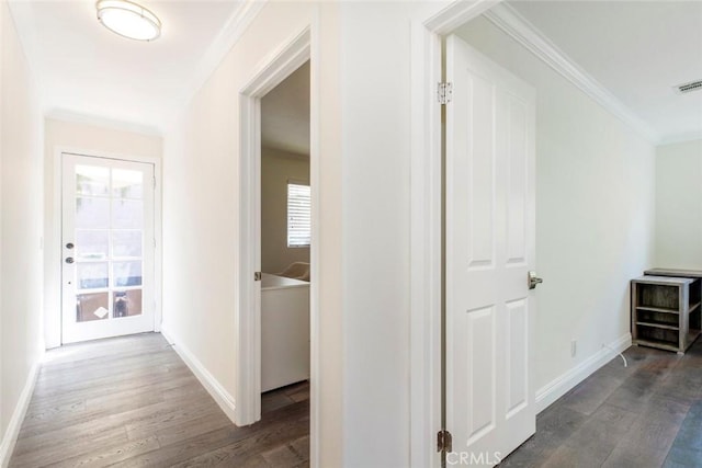hall featuring ornamental molding, baseboards, and wood finished floors