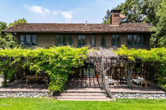 rear view of property with a chimney and a patio area