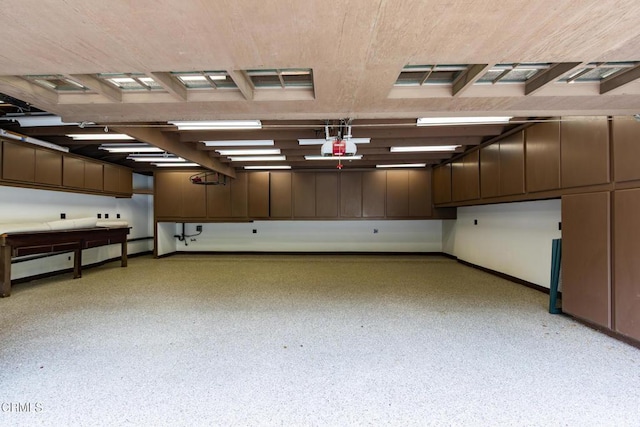 garage featuring baseboards, a garage door opener, and a baseboard heating unit