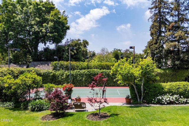view of community with a tennis court and a lawn