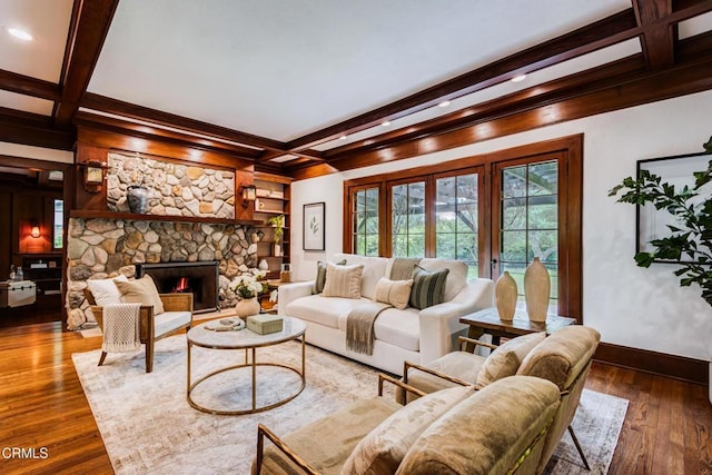 living area featuring baseboards, beamed ceiling, and coffered ceiling