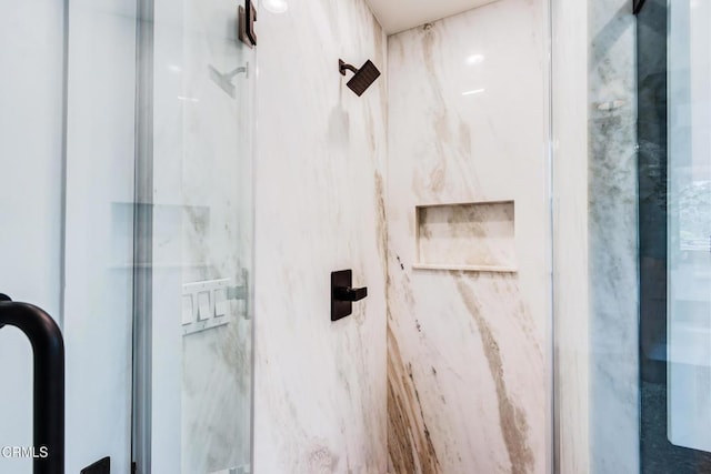 bathroom featuring a marble finish shower