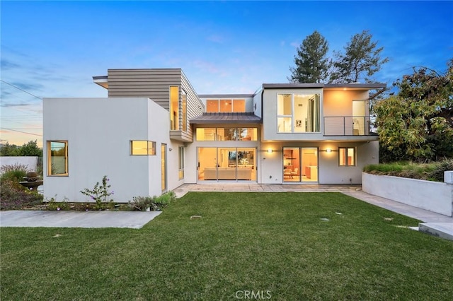 1145 E Grandview Ave, Sierra Madre, CA 91024 - rear view of house with a balcony, a standing seam roof, a yard, metal roof, and stucco siding