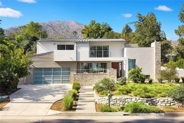 1145 E Grandview Ave, Sierra Madre, CA 91024 - contemporary house featuring stucco siding, concrete driveway, a mountain view, and stone siding