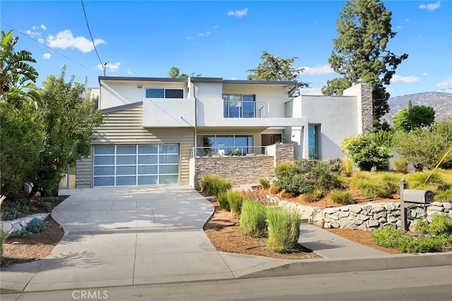 1145 E Grandview Ave, Sierra Madre, CA 91024 - contemporary home with concrete driveway, stucco siding, an attached garage, and stone siding