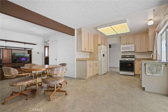 kitchen featuring a textured ceiling, beam ceiling, a sink, and white appliances