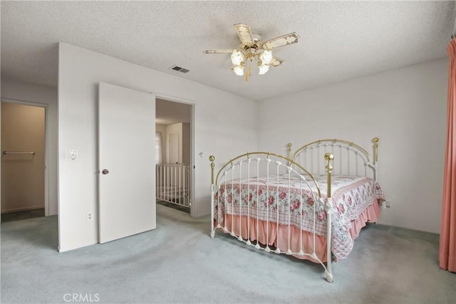 bedroom featuring a textured ceiling, visible vents, and carpet floors