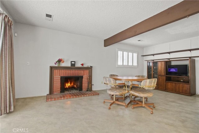 carpeted dining room with beamed ceiling, a brick fireplace, visible vents, and a textured ceiling
