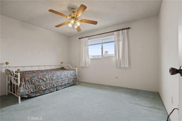 bedroom featuring carpet flooring, a textured ceiling, and ceiling fan