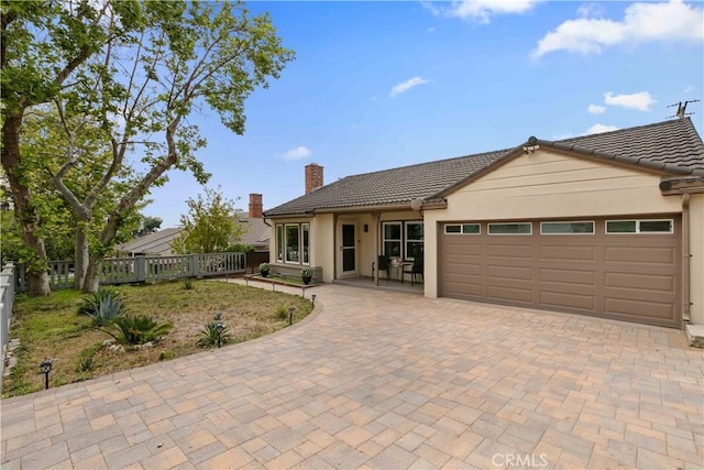 3348 Burritt Way, La Crescenta, CA 91214 - single story home featuring an attached garage, a tile roof, a chimney, fence, and decorative driveway