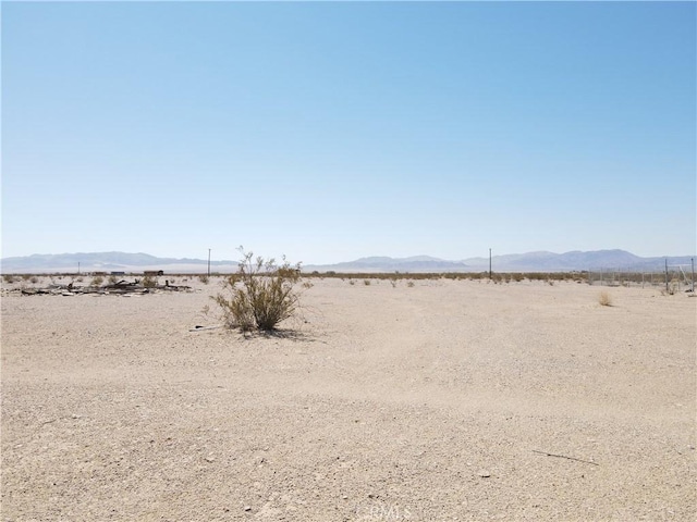 view of yard featuring a mountain view, a desert view, and a rural view