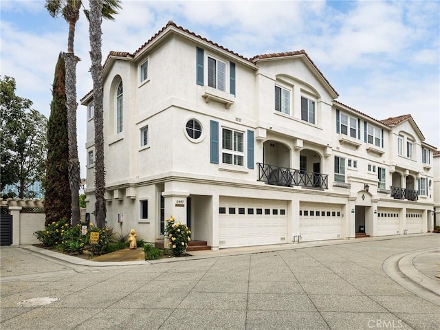 5447 Marine Ave Unit 7, Lawndale, CA 90260 - view of property with a tile roof, a garage, stucco siding, and driveway