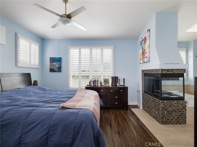 5447 Marine Ave Unit 7, Lawndale, CA 90260 - bedroom with a tile fireplace, a ceiling fan, multiple windows, and wood finished floors