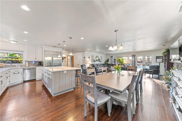 dining area with a chandelier, dark wood-type flooring, plenty of natural light, and recessed lighting