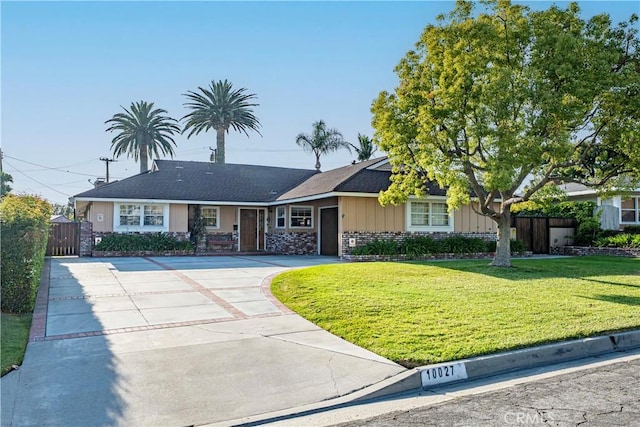 ranch-style house with a gate, fence, an attached garage, concrete driveway, and a front yard