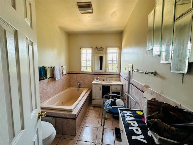 606 W 57th St, Los Angeles, CA 90037 - full bathroom with a whirlpool tub, vanity, tile patterned flooring, and toilet
