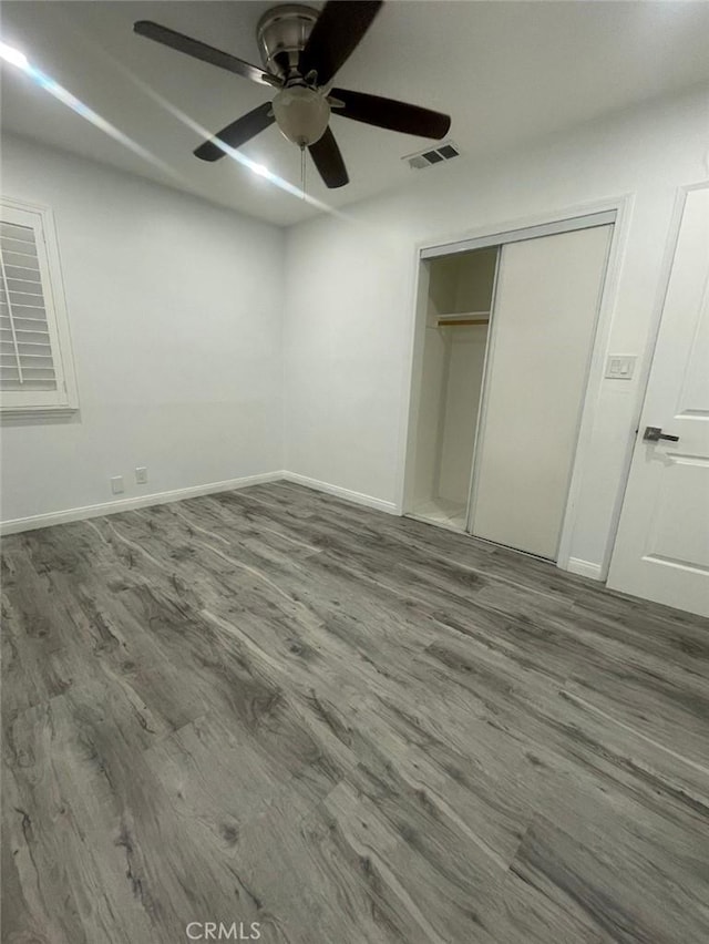 unfurnished bedroom featuring visible vents, wood finished floors, and baseboards