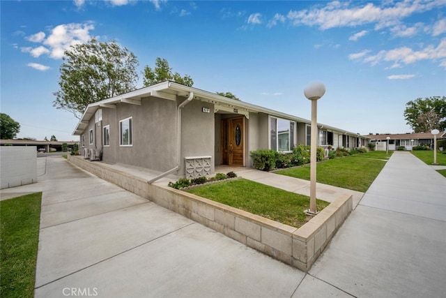view of front of property with a front lawn and stucco siding