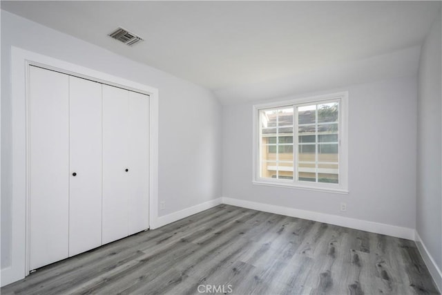 3500 W Manchester Blvd Unit 15, Inglewood, CA 90305 - unfurnished bedroom featuring a closet, baseboards, visible vents, vaulted ceiling, and wood finished floors