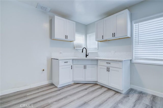 3731 Glendon Ave, Los Angeles, CA 90034 - kitchen with a sink, visible vents, light wood-style flooring, light countertops, and white cabinets