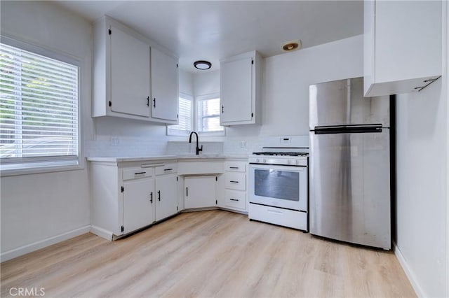 3731 Glendon Ave, Los Angeles, CA 90034 - kitchen with freestanding refrigerator, light countertops, white range with gas stovetop, and a sink