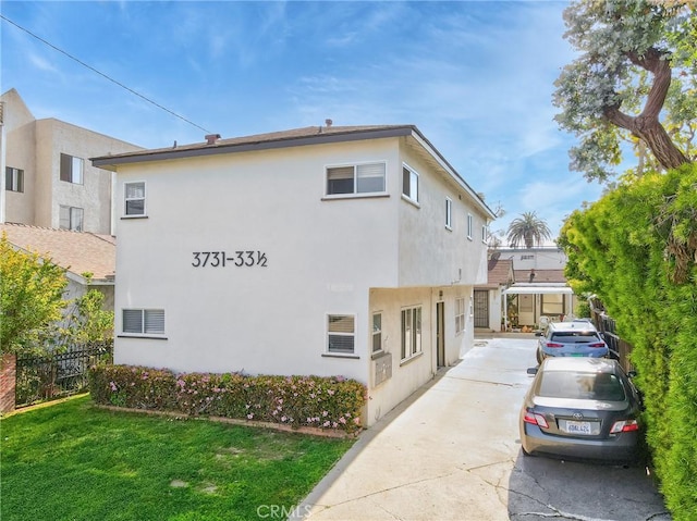 3731 Glendon Ave, Los Angeles, CA 90034 - view of property exterior with a yard, fence, stucco siding, and driveway