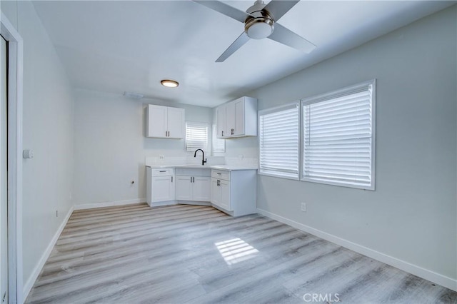 3731 Glendon Ave, Los Angeles, CA 90034 - kitchen featuring baseboards, light wood finished floors, white cabinets, and a sink