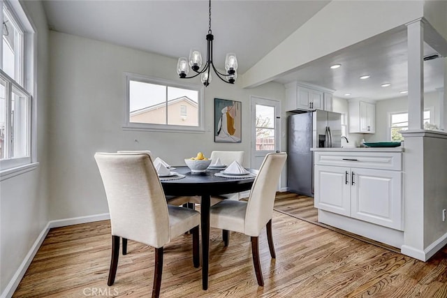 dining space with baseboards, a notable chandelier, recessed lighting, and light wood-style floors