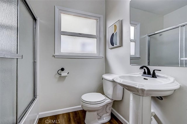 full bathroom with toilet, enclosed tub / shower combo, wood finished floors, and baseboards
