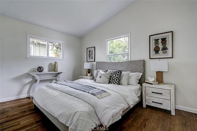 bedroom with vaulted ceiling, dark wood-style flooring, and baseboards