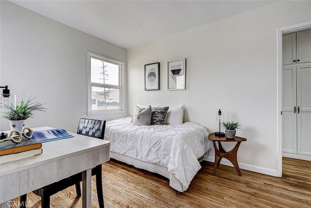 bedroom with baseboards and wood finished floors